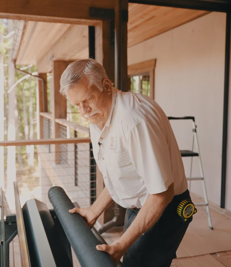 a professional window screen installer installing a retractible screen on a luxury home outdoor space